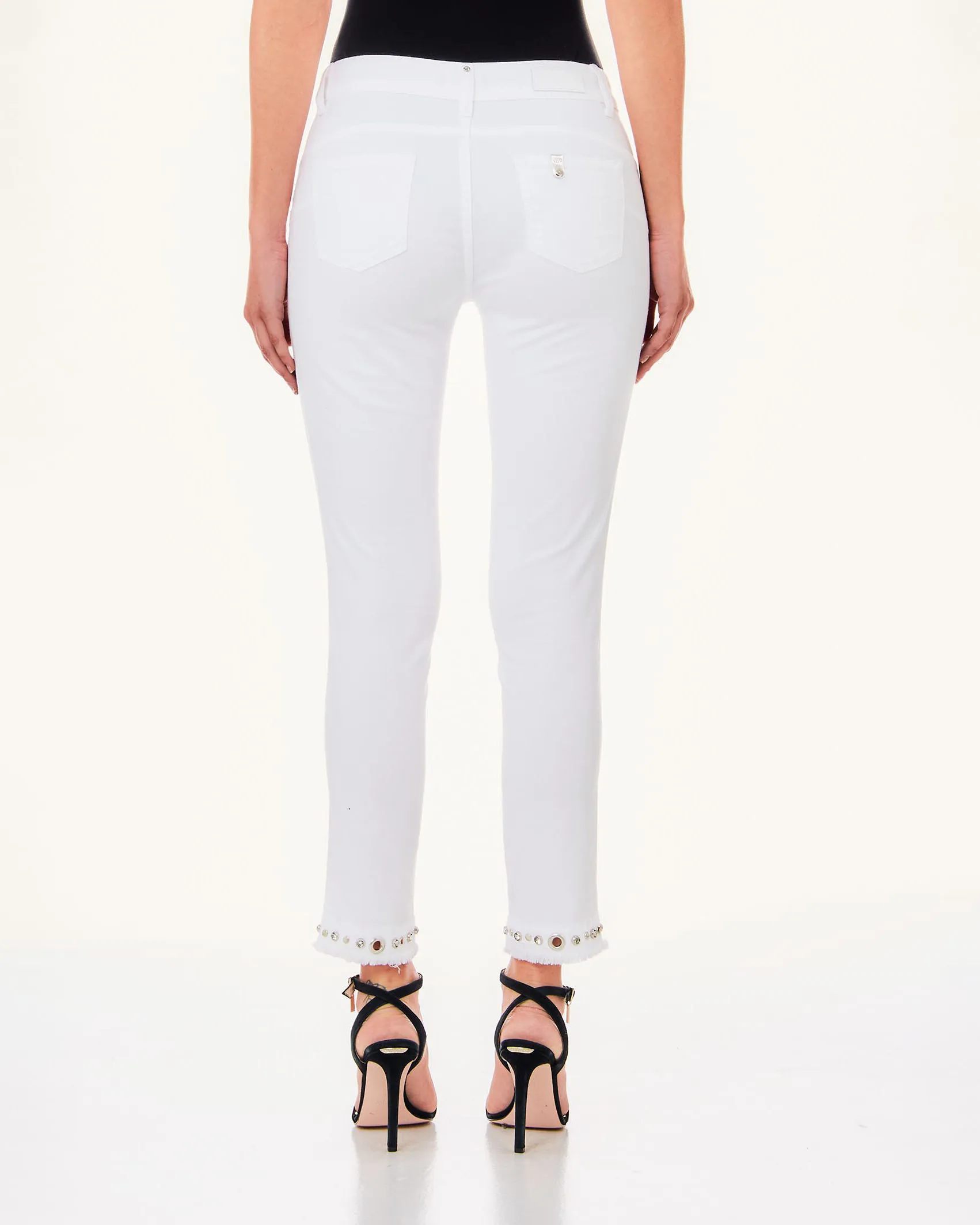 Jeans bianchi skinny in cotone stretch con borchie incastonate sul fondo